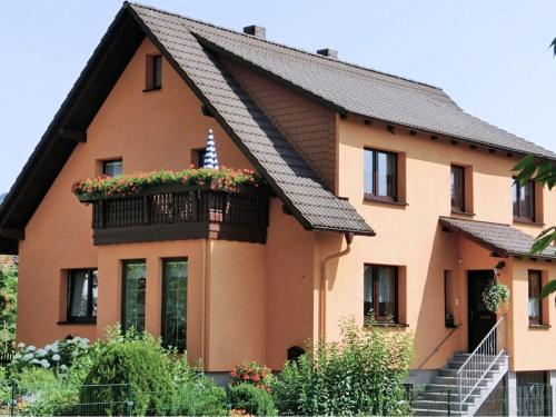 a house with a balcony with flowers on it at Holiday home in the Thuringian Forest in Seligenthal