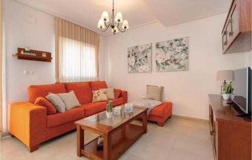 a living room with an orange couch and a table at Gorgeous Apartment In Roldán With Wifi in Los Tomases