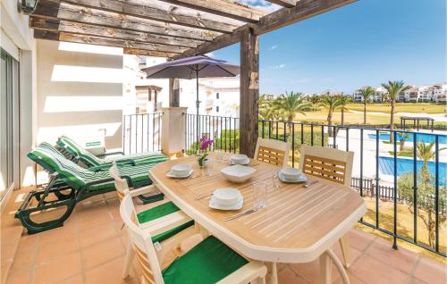 a wooden table and chairs on a balcony with the ocean at Gorgeous Apartment In Roldán With Wifi in Los Tomases
