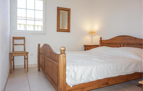 ein Schlafzimmer mit einem Holzbett und einem Stuhl in der Unterkunft 3 Bedroom Awesome Home In Saint Pons De Mauchien in Saint-Pons-de-Mauchiens
