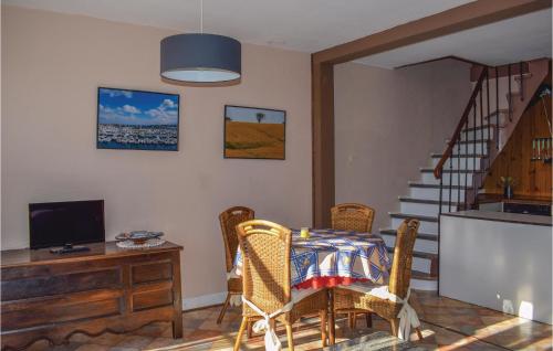 a living room with a table and chairs and a television at Two-Bedroom Holiday Home In Saint Cast Le Guildo in LʼIsle-Saint-Cast