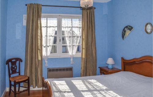 Schlafzimmer mit blauen Wänden, einem Bett und einem Fenster in der Unterkunft Amazing Home In Saint Cast Le Guildo With House Sea View in LʼIsle-Saint-Cast