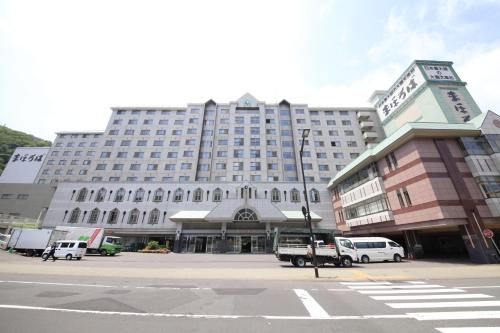 a large building with cars parked in front of it at Hotel Mahoroba in Noboribetsu