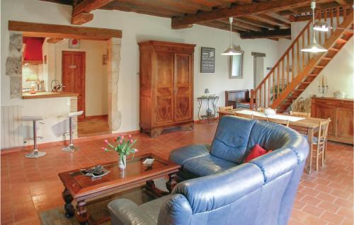 a living room with a blue leather couch and a table at Chouchou, Le Bourg in Laveyssière