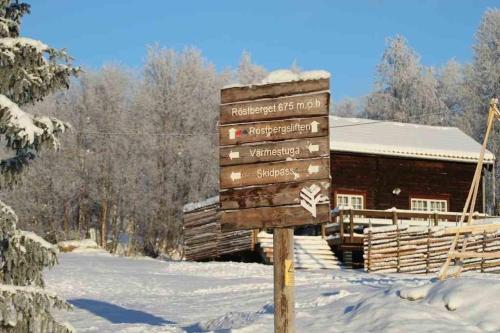 a sign in the snow in front of a cabin at Funäs Ski Lodge in Funäsdalen