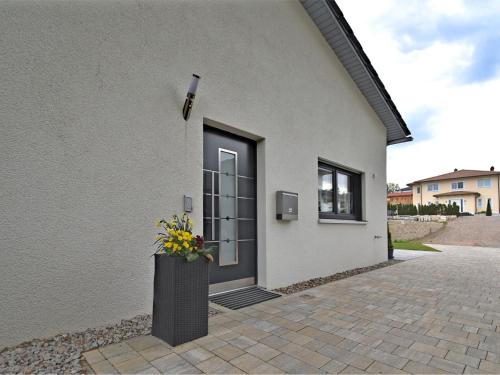 a building with a black door with a vase of flowers at Holiday home with garden near Hammersee in Bodenwöhr