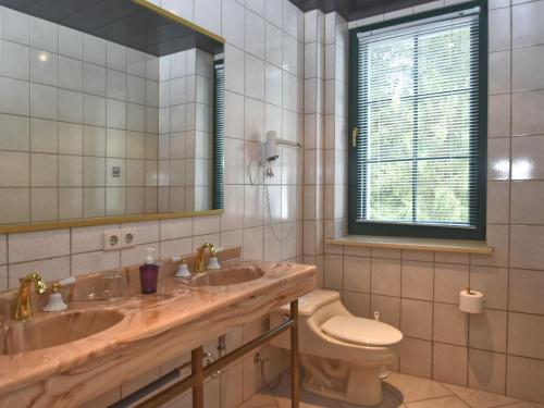 a bathroom with two sinks and a toilet and a mirror at Retreat with Sauna, Hot Tub in Jägersgrün