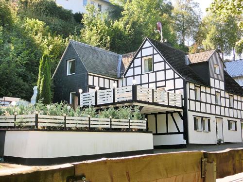 a black and white house with a garden in front of it at Beautiful holiday home near the ski area in Schmallenberg