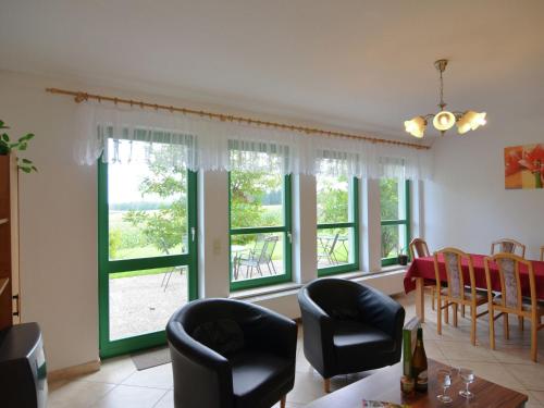 バート・シャンダウにあるDetached holiday home in Saxony with gorgeous viewのリビングルーム(窓、テーブル、椅子付)