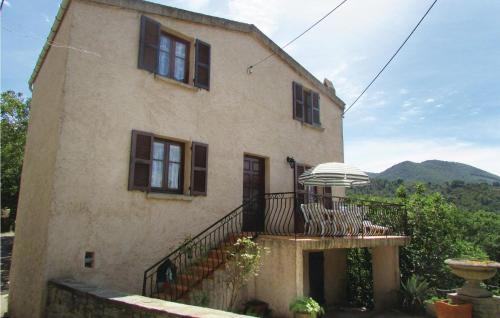 Cette maison dispose d'un balcon avec une table et un parasol. dans l'établissement Gorgeous Home In Valle Di Rostino, à Casapitti