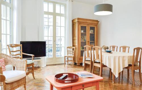 ein Wohnzimmer mit Tisch und Stühlen und einem Fernseher in der Unterkunft Nice Apartment In Mers-Les-Bains in Mers-les-Bains