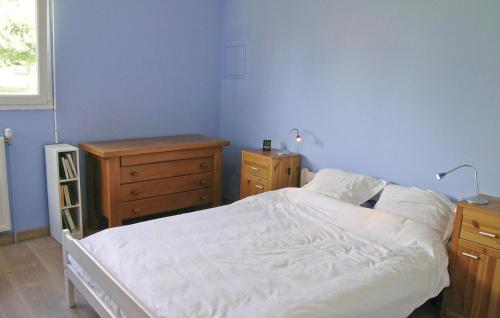 a bedroom with a white bed and a wooden dresser at Gorgeous Home In Plouha With Kitchenette in Plouha