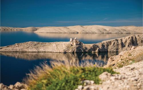 a body of water with a building on the shore at 2 Bedroom Beautiful Apartment In Pag in Pag