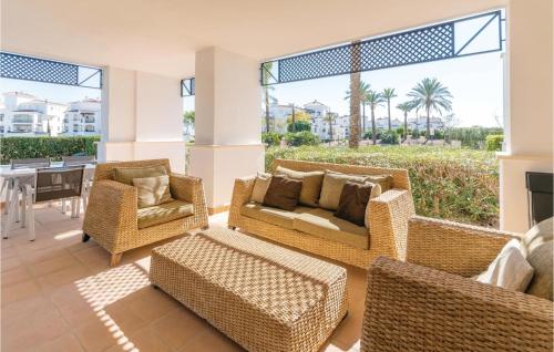 a living room with wicker furniture and a table at 2 Bedroom Amazing Apartment In Roldán in Los Tomases