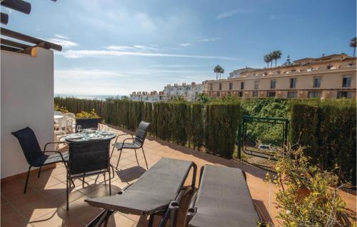 eine Terrasse mit Tischen und Stühlen und einem Zaun in der Unterkunft Awesome Home In Mijas Costa With Wifi in Mijas Costa