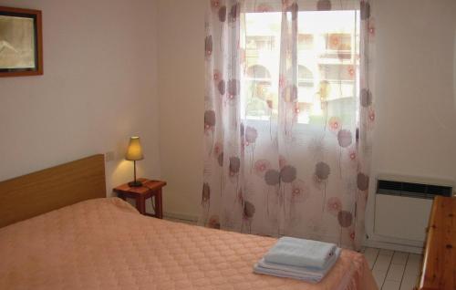 een slaapkamer met een bed en een raam bij Amazing Apartment In Argeles Sur Mer With Kitchen in Plage dʼArgelès