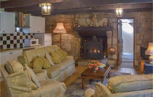 a living room with a couch and a fireplace at Amazing Home In Guern With Wifi in Guern