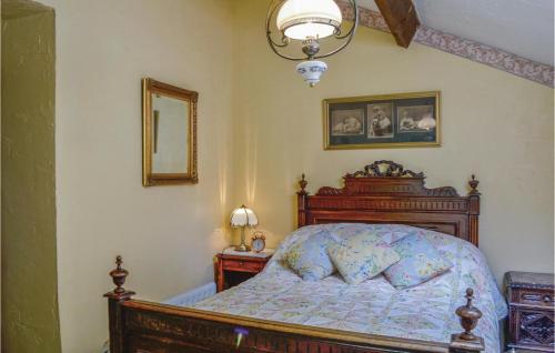 ein Schlafzimmer mit einem Bett, einer Lampe und einem Spiegel in der Unterkunft Amazing Home In Guern With Wifi in Guern