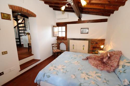 a bedroom with a bed with a blue comforter at Agriturismo Villa Iris in Castelfranco di Sopra