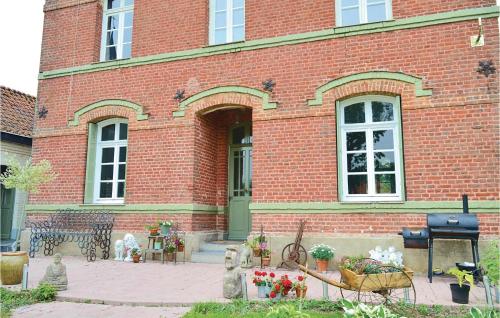 a brick building with a bench and flowers in front of it at Beautiful Home In Fressin With Kitchen in Fressin