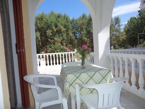 a table with a vase of flowers on a balcony at renesis studios in Lithakia