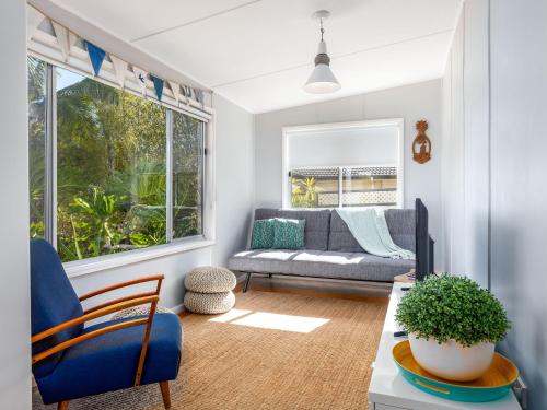 a living room with a couch and a table at Sirocco Cottage - pet-friendly Huskisson home in Huskisson