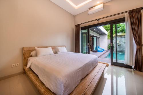 Un dormitorio con una cama y una ventana grande. en Viros Luxury Villa 2BR Private Pool, en Jimbaran