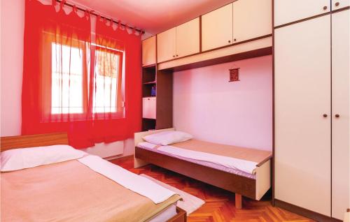 Gorgeous Apartment In Selce With Wifi في سيلتسي: سريرين في غرفة بجدران حمراء