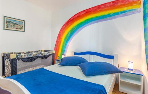 a bedroom with a bed with a rainbow on the wall at 3 Bedroom Pet Friendly Apartment In Viskovo in Viskovo