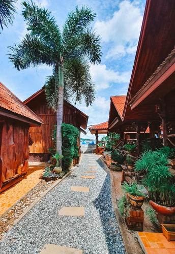 a pathway with a palm tree in a resort at Homebeach Resort เกาะล้าน in Ko Larn