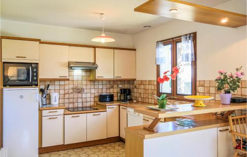 une cuisine avec des armoires blanches et un réfrigérateur blanc dans l'établissement Holiday Home Rue De Seychelles, à Pirou