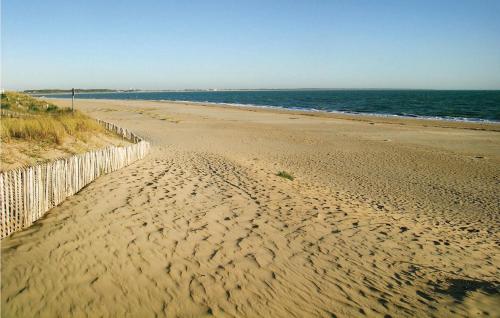 une plage de sable au bord de l'océan avec une clôture dans l'établissement Awesome Home In La Tranche Sur Mer, à La Tranche-sur-Mer