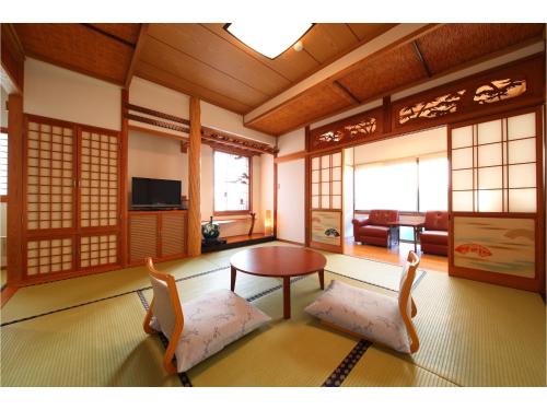 a living room with a table and two chairs at Kakureisen in Saga