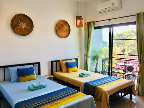 2 Betten in einem Zimmer mit Fenster in der Unterkunft Mae-Sa-Riang Home in Mae Sariang
