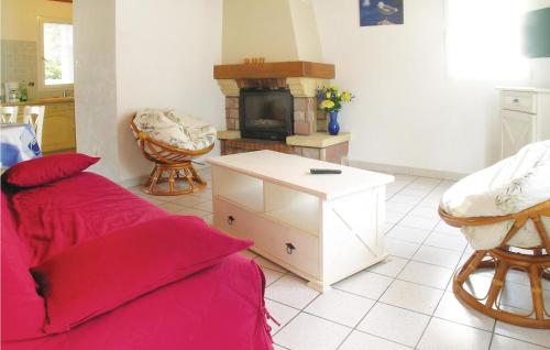 a living room with a red couch and a fireplace at Three-Bedroom Holiday Home In La Tranche Sur Mer in La Tranche-sur-Mer