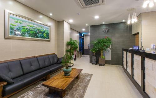 a lobby with a couch and a table in a room at Harmony Hotel in Seoul