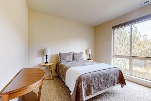 una camera da letto con un letto, un tavolo e una finestra di Eagle Crest Highland Getaway a Redmond