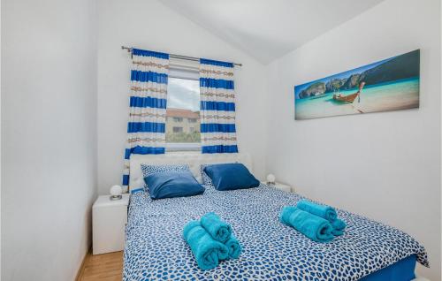 a bedroom with a bed with blue sheets and blue pillows at 2 Bedroom Awesome Home In Kras in Kras