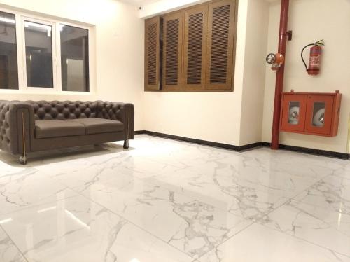 a living room with a couch and marble floor at The Kings Park Grand-Near US Consulate in Chennai