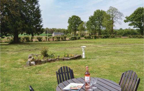 - une bouteille de vin assise sur une table dans un champ dans l'établissement Stunning Home In Fougerolles Du Plessis, à Fougerolles-du-Plessis