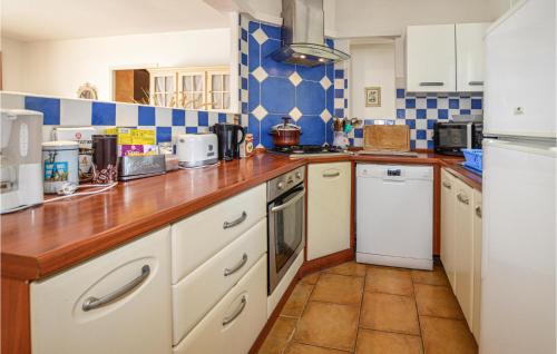 - une cuisine avec des placards blancs et du carrelage bleu et blanc dans l'établissement 2 Bedroom Gorgeous Home In Aleria, à Aléria