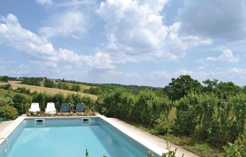 una piscina in un giardino con due sedie di Awesome Home In La-Chapelle-Saint-Jean a La Chapelle-Saint-Jean