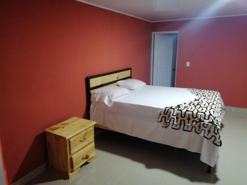 a bedroom with a bed and a wooden night stand at Room in Guest room - Piscalonga Hotel Restaurant Cozy Family Operated in San Lorenzo de Guayubín