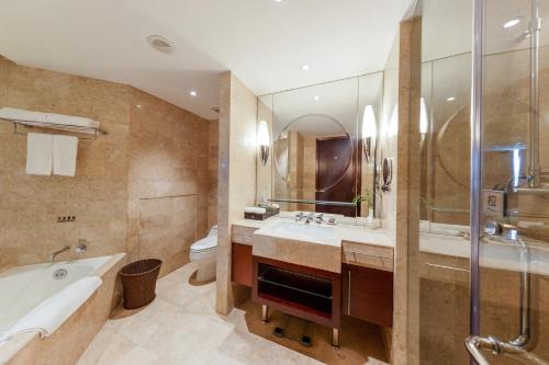 a bathroom with a tub and a sink and a toilet at Park Plaza Changzhou, A member of Radisson Hotel&Resorts in Changzhou