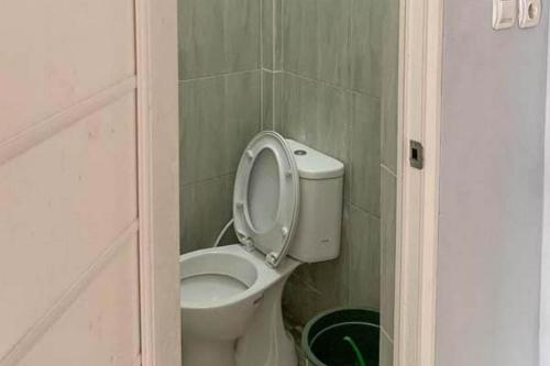 a bathroom with a toilet with the lid up at Kai Homestay Near Anyer Beach RedPartner in Kareo