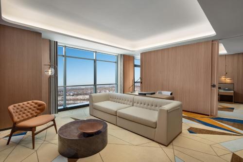 a living room with a couch and a large window at La Quinta by Wyndham Weifang South in Weifang