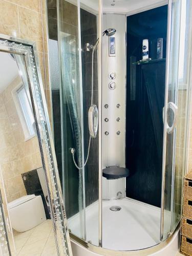 una ducha con puerta de cristal en un baño en Beach Shack Apartment, en Shanklin