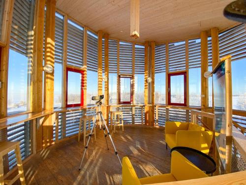 a room with yellow chairs and a camera on a balcony at Hotelli Liminganlahti in Liminka