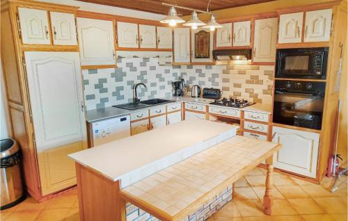 une cuisine avec des armoires en bois et un comptoir blanc dans l'établissement Three-Bedroom Holiday Home In Ruffiac, à Ruffiac