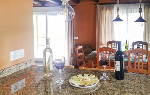 a counter with two glasses of wine and wine bottles at Pet Friendly Home In Algatocin in Algatocín